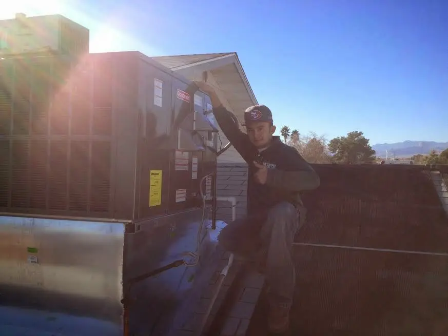 HVAC technician performing AC Tune-Up on a rooftop unit in Kahaluu
